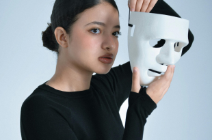 Vrouw neemt haar wit toneelmasker af